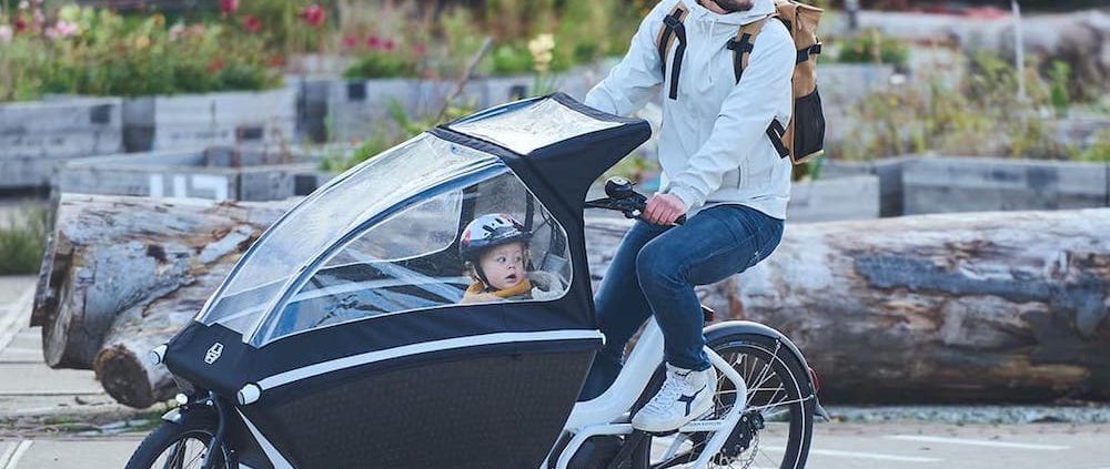 A man is riding Urban Arrow Crago ebike with his child