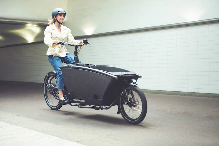 A woman rides an Urban Arrow Family electric cargo bike