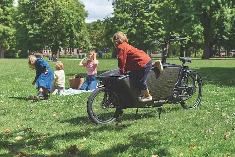 Femme et enfants dans un parc avec un vélo cargo familial Urban Arrow